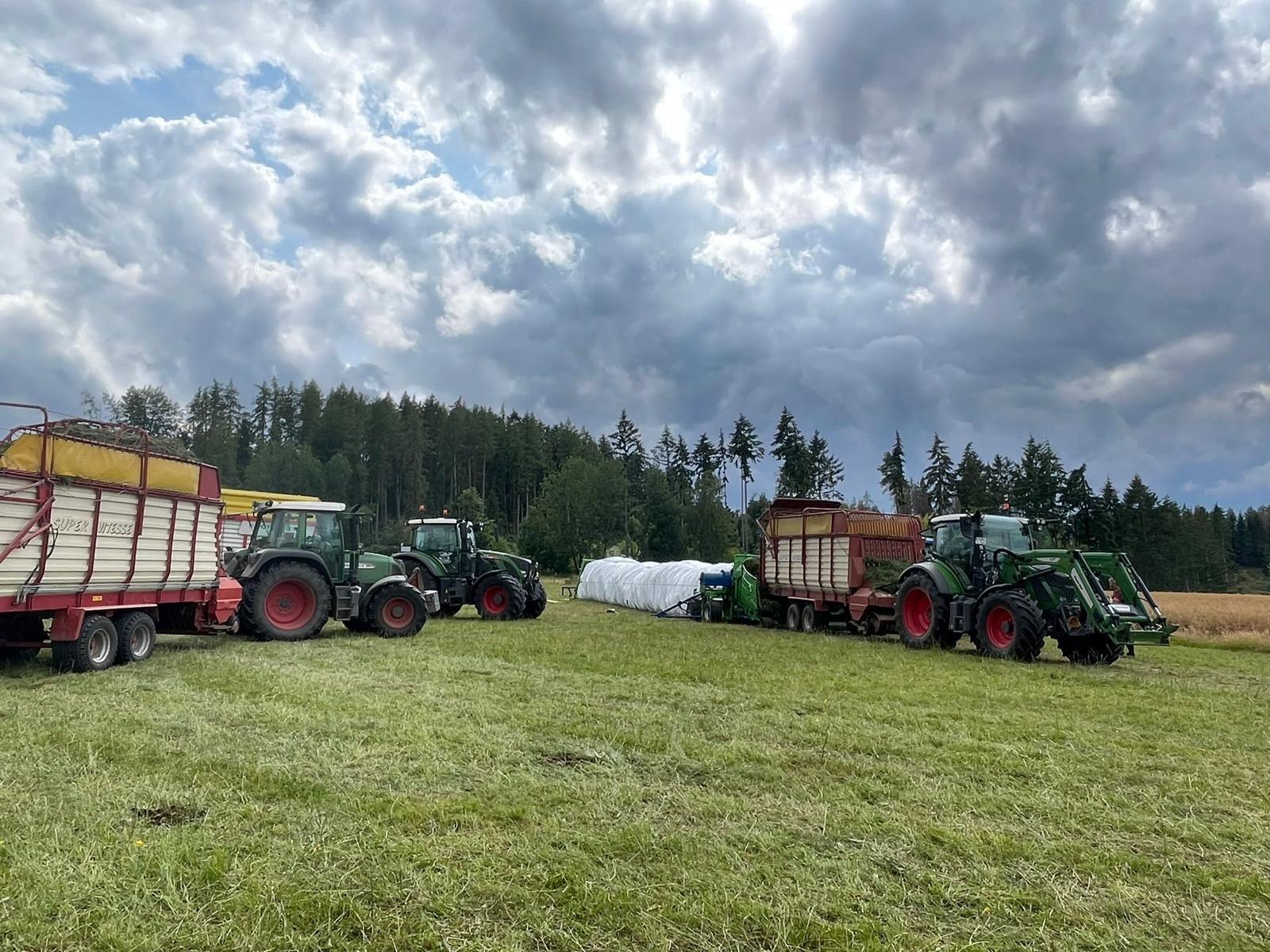 Silage-Schlauchpressen mit Fendt-Traktoren und SUPER VITESSE-Ladewagen auf dem Grünland